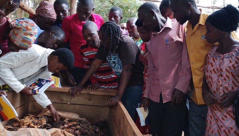Des agriculteurs observent un bac de compost pendant une formation